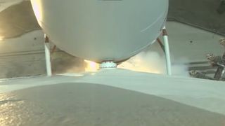 a top-down view of a launch pad engulfed in flame as seen from a camera aboard a rocket during lift off